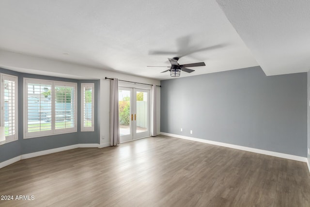 empty room with hardwood / wood-style floors, ceiling fan, a textured ceiling, and french doors