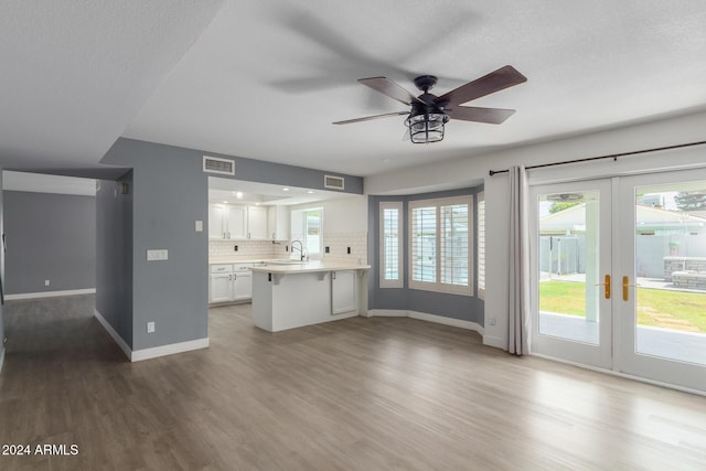 kitchen featuring kitchen peninsula, french doors, decorative backsplash, ceiling fan, and white cabinets