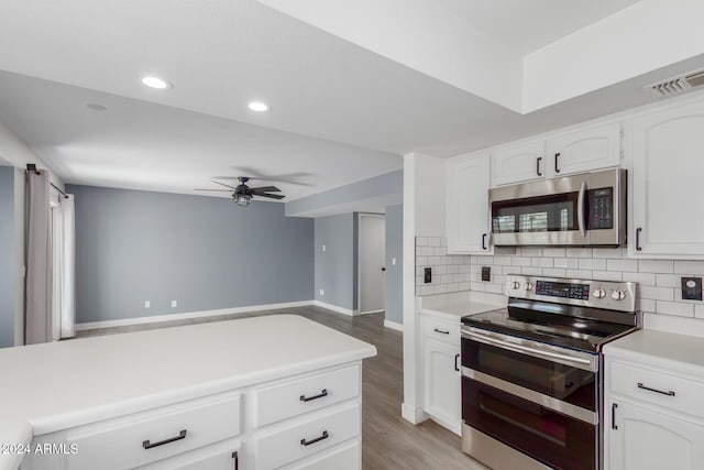 kitchen featuring decorative backsplash, appliances with stainless steel finishes, white cabinetry, and ceiling fan