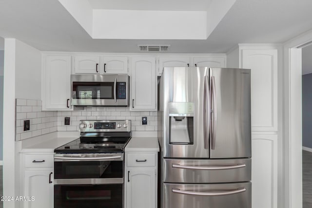 kitchen featuring tasteful backsplash, white cabinetry, and stainless steel appliances