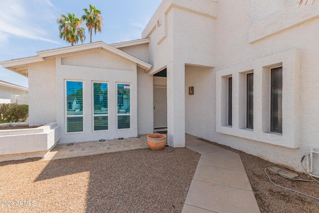 view of exterior entry featuring a patio