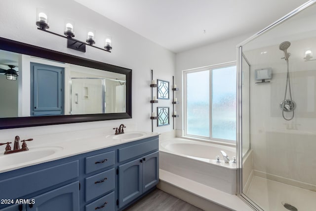 bathroom featuring plus walk in shower, wood-type flooring, and vanity