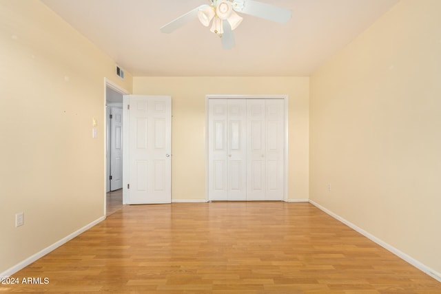 unfurnished bedroom with ceiling fan, a closet, and light wood-type flooring