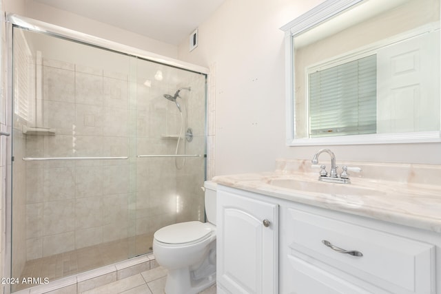 bathroom featuring tile patterned floors, vanity, toilet, and walk in shower