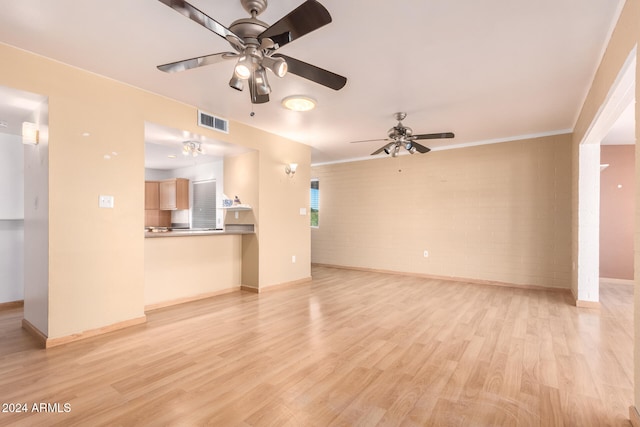 unfurnished living room featuring ceiling fan, light hardwood / wood-style floors, and brick wall