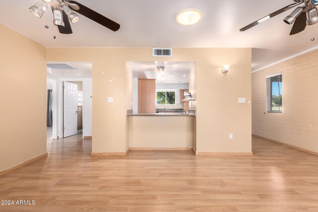 unfurnished living room featuring light hardwood / wood-style flooring and brick wall