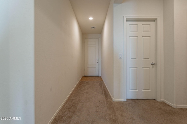 hallway featuring light colored carpet