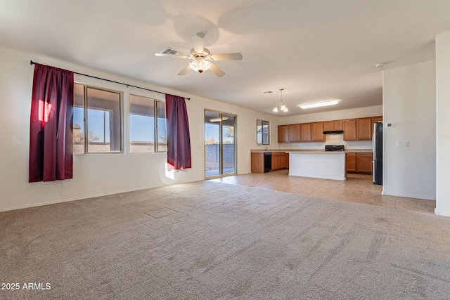 unfurnished living room featuring light carpet and ceiling fan with notable chandelier