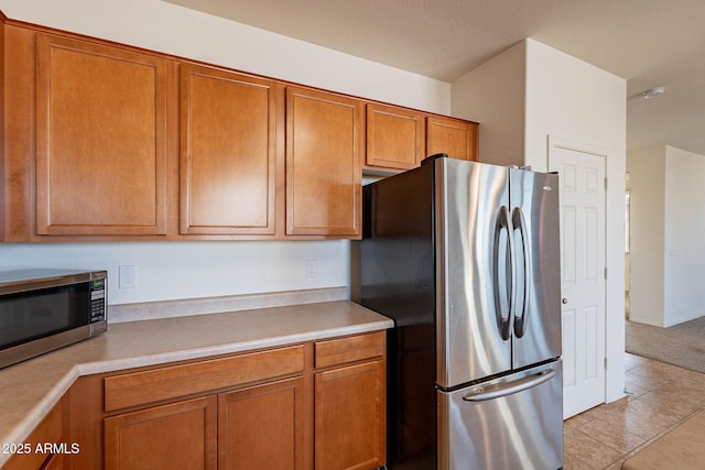 kitchen with light tile patterned floors and stainless steel appliances