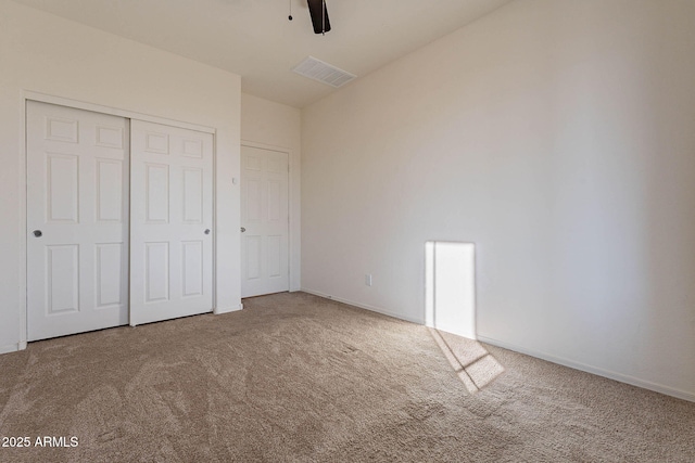 unfurnished bedroom featuring ceiling fan, a closet, and carpet