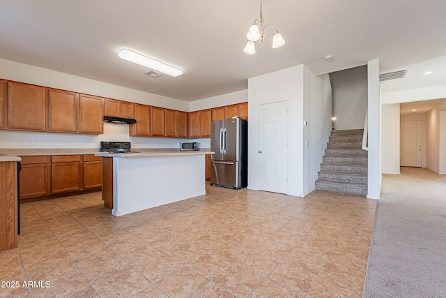 kitchen featuring a kitchen island, light carpet, stainless steel appliances, hanging light fixtures, and a notable chandelier