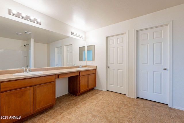 bathroom with vanity and tiled shower