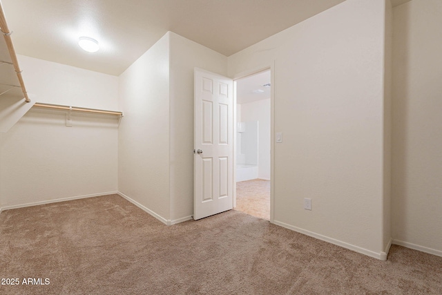 walk in closet with light colored carpet