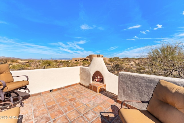 view of patio / terrace with a lit fireplace