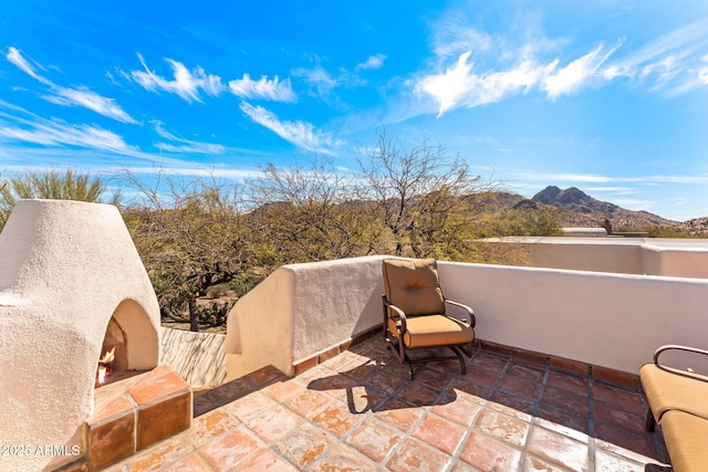 view of patio / terrace with a mountain view and a lit fireplace