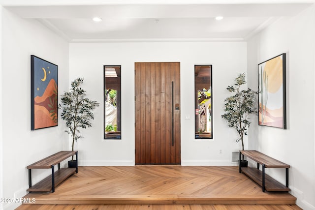 entrance foyer featuring baseboards, ornamental molding, and recessed lighting