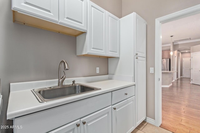 3034 E Turney Ave, Phoenix, AZ 85016 - kitchen with freestanding refrigerator, a sink, white cabinetry, light countertops, and baseboards