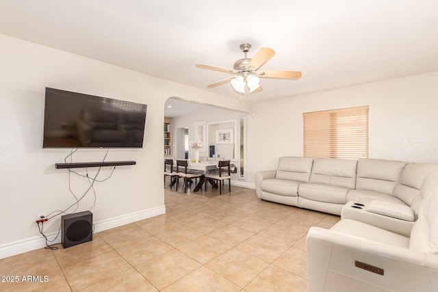 living area with light tile patterned flooring, baseboards, and ceiling fan