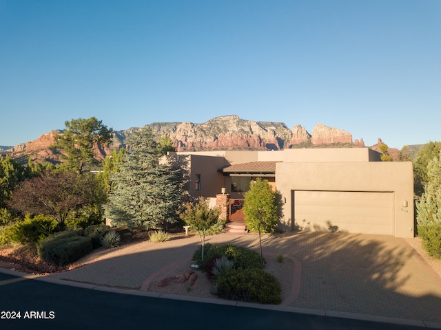 pueblo revival-style home with a mountain view and a garage