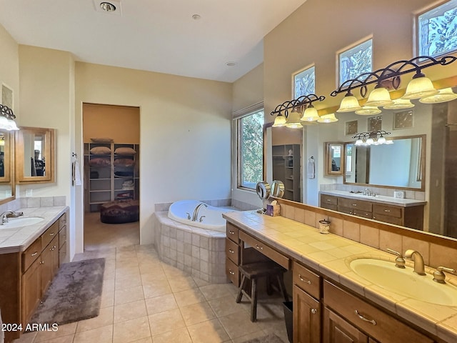 bathroom featuring vanity, tile patterned floors, and a relaxing tiled tub