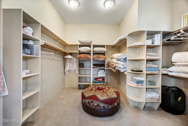 walk in closet featuring light carpet