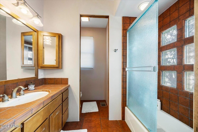 bathroom featuring vanity, enclosed tub / shower combo, and tile patterned floors