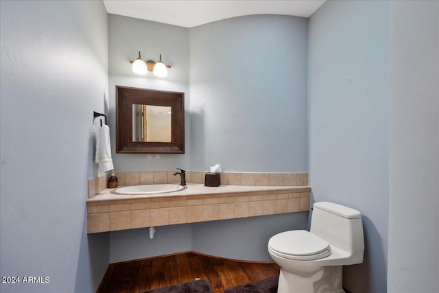 bathroom featuring wood-type flooring, sink, and toilet