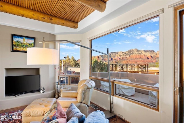 sunroom / solarium with beamed ceiling, a mountain view, and wooden ceiling