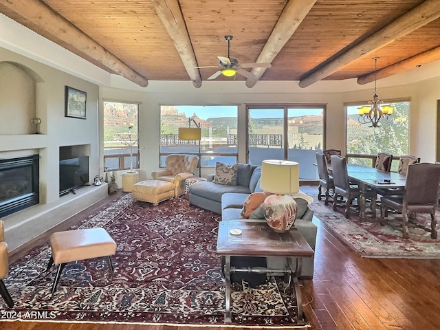 living room featuring a healthy amount of sunlight, dark hardwood / wood-style flooring, and beam ceiling