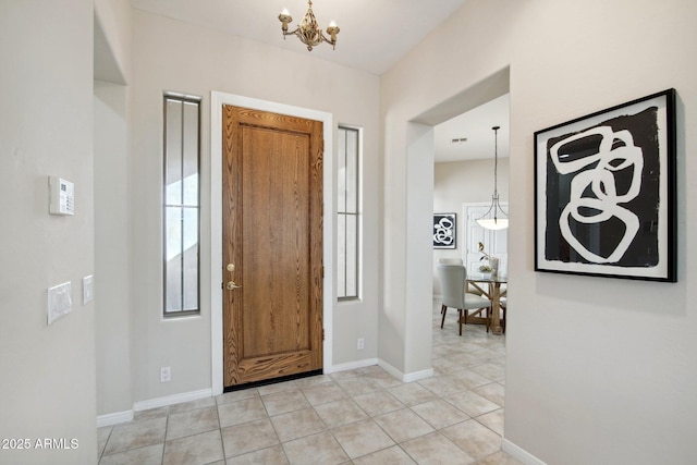 entryway featuring light tile patterned flooring and a chandelier