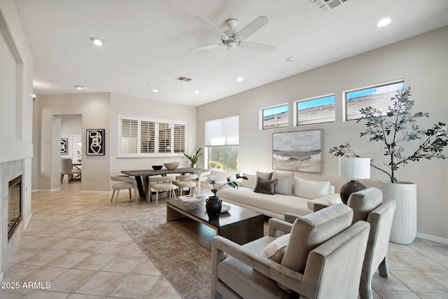 living room with ceiling fan, a premium fireplace, and light tile patterned flooring