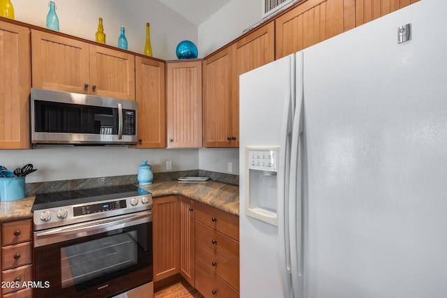 14300 W Bell Rd Unit 312, Surprise, AZ 85374 - kitchen featuring appliances with stainless steel finishes, brown cabinetry, and light wood-style floors