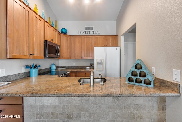 14300 W Bell Rd Unit 312, Surprise, AZ 85374 - kitchen featuring appliances with stainless steel finishes, a peninsula, a sink, and light stone countertops