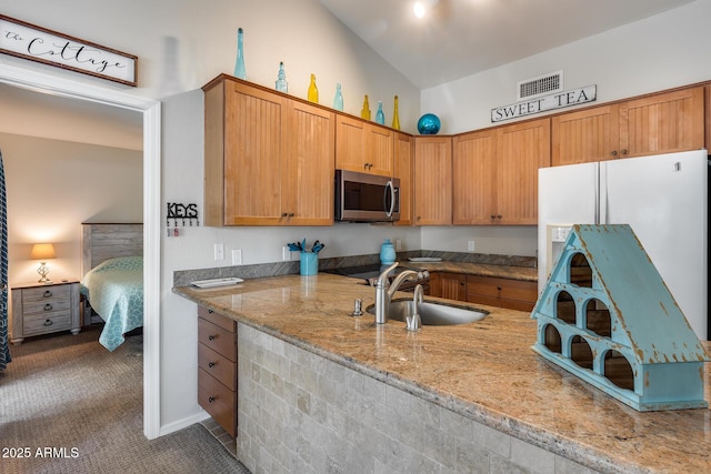 14300 W Bell Rd Unit 312, Surprise, AZ 85374 - kitchen with stainless steel microwave, a sink, light stone countertops, carpet flooring, and high vaulted ceiling