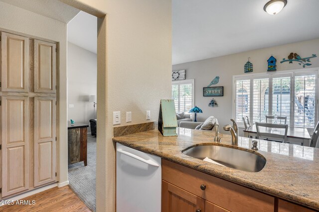 14300 W Bell Rd Unit 312, Surprise, AZ 85374 - kitchen with dishwasher, a sink, light stone counters, light wood-type flooring, and open floor plan