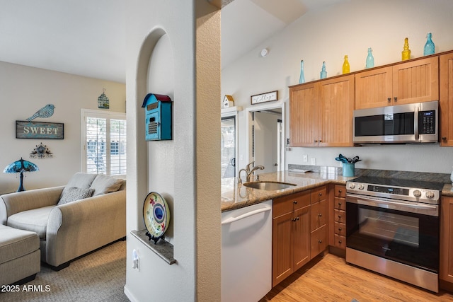 14300 W Bell Rd Unit 312, Surprise, AZ 85374 - kitchen with stainless steel appliances, a sink, open floor plan, stone counters, and light wood finished floors