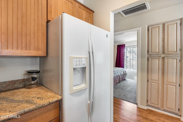 14300 W Bell Rd Unit 312, Surprise, AZ 85374 - kitchen with white fridge with ice dispenser, light wood-style floors, and light stone countertops