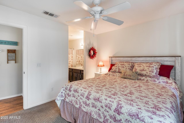 14300 W Bell Rd Unit 312, Surprise, AZ 85374 - bedroom with baseboards, a ceiling fan, and connected bathroom