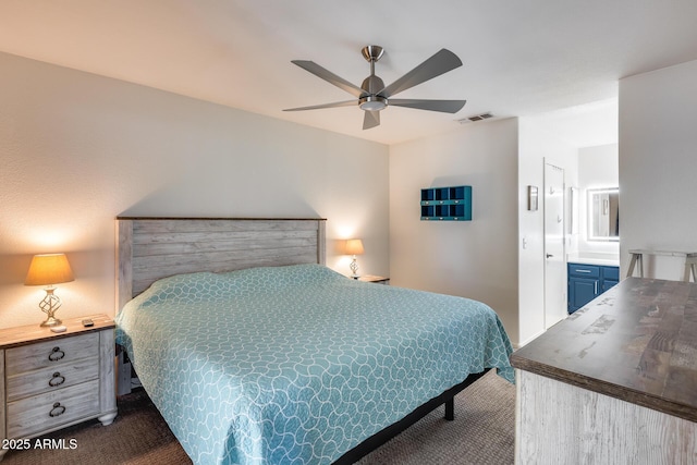 14300 W Bell Rd Unit 312, Surprise, AZ 85374 - bedroom with dark carpet, ensuite bathroom, and a ceiling fan