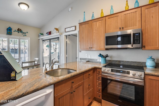 14300 W Bell Rd Unit 312, Surprise, AZ 85374 - kitchen featuring stainless steel appliances, a sink, light stone counters, and brown cabinetry