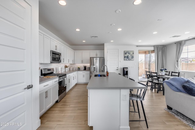 21241 E Superstition Dr, Queen Creek, AZ 85142 - kitchen with visible vents, a breakfast bar area, decorative backsplash, appliances with stainless steel finishes, and a sink