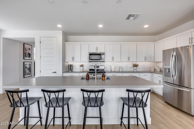 21241 E Superstition Dr, Queen Creek, AZ 85142 - kitchen featuring light wood finished floors, decorative backsplash, white cabinets, stainless steel appliances, and a sink