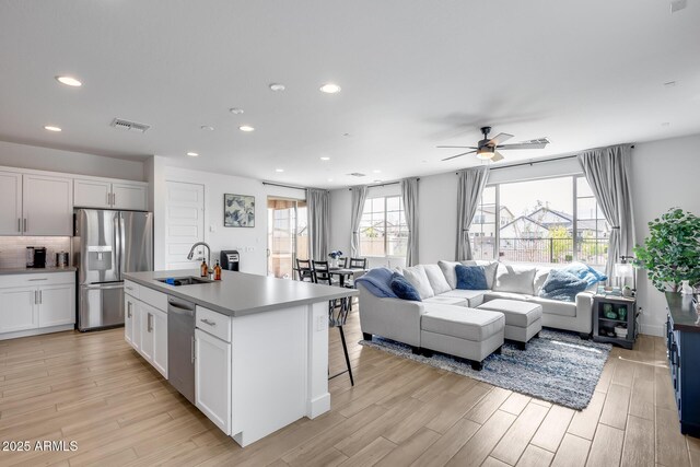 21241 E Superstition Dr, Queen Creek, AZ 85142 - kitchen with light wood-type flooring, a ceiling fan, a sink, open floor plan, and appliances with stainless steel finishes