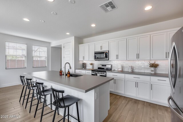 21241 E Superstition Dr, Queen Creek, AZ 85142 - kitchen with visible vents, light wood-type flooring, decorative backsplash, stainless steel appliances, and a sink