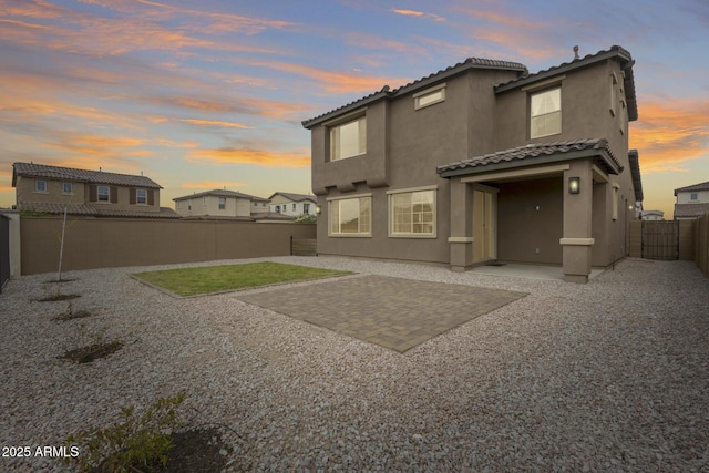 21241 E Superstition Dr, Queen Creek, AZ 85142 - back of property at dusk featuring stucco siding, a patio, a fenced backyard, and a tile roof