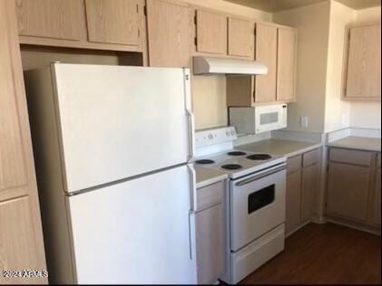 kitchen featuring dark hardwood / wood-style flooring, white appliances, and light brown cabinetry