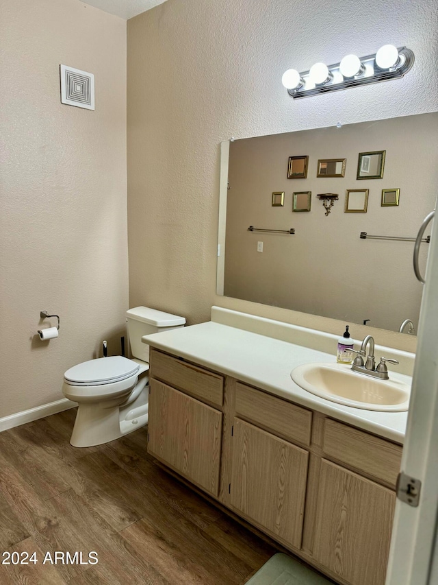 bathroom with hardwood / wood-style floors, vanity, and toilet