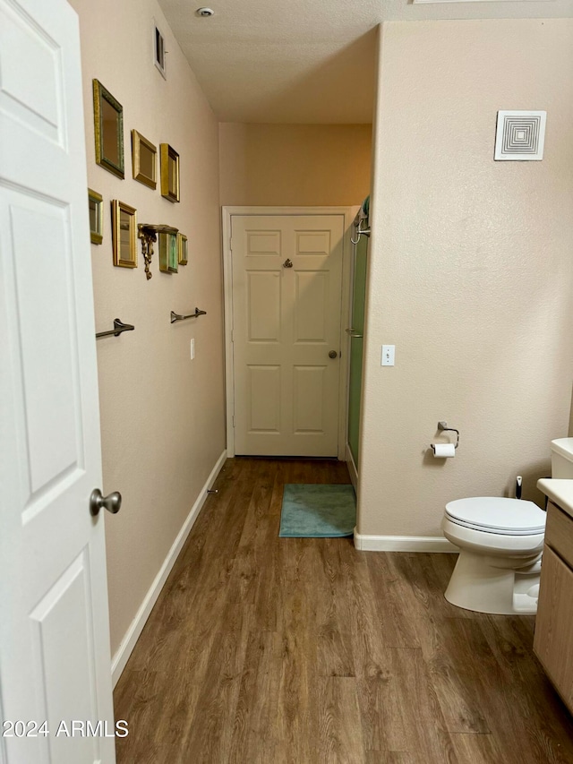 bathroom featuring vanity, hardwood / wood-style flooring, and toilet