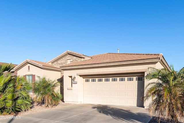 view of front of house featuring stucco siding, concrete driveway, and a garage