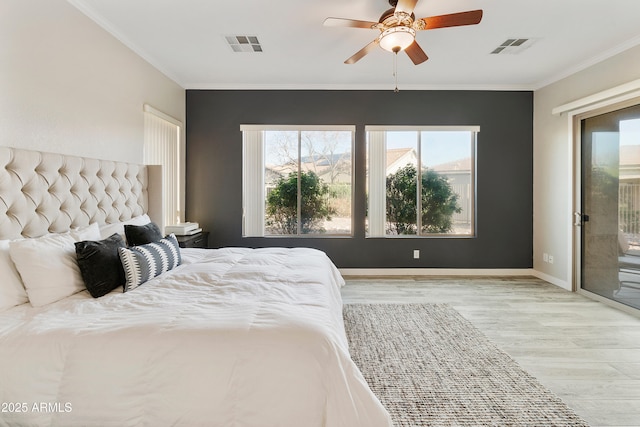 bedroom with visible vents, crown molding, baseboards, and wood finished floors